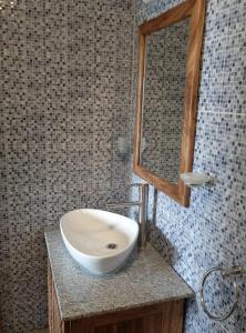 a bathroom with a sink and a mirror at BUNGALOW'S PLAZA KRIBI in Kribi