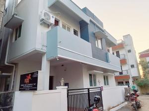 a white building with a balcony and a fence at KBS Home Ramapuram in Chennai