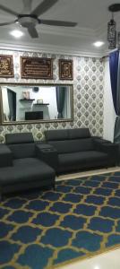 a living room with a couch and a mirror at FH Homestay 4BR in Wakaf Baharu