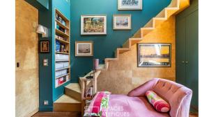 a living room with a pink couch and stairs at Paris Best view w/Rooftop! in Paris