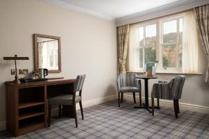 a room with a desk and chairs and a window at The Ullswater Inn- The Inn Collection Group in Glenridding