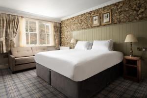 a bedroom with a large bed and a couch at The Ullswater Inn- The Inn Collection Group in Glenridding