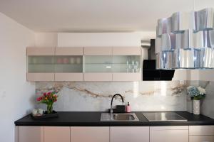 a kitchen with white cabinets and a sink at Central Elite Vista-with parking in Ljubljana