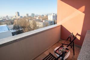 a balcony with a chair and a view of a city at Central Elite Vista-with parking in Ljubljana