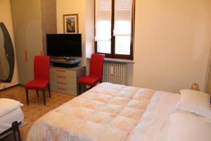 um quarto com uma cama e 2 cadeiras vermelhas em Carlo Cacciami em Grignasco