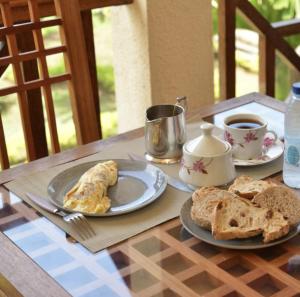 uma mesa com pratos de comida e pão em BUNGALOW'S PLAZA KRIBI em Kribi