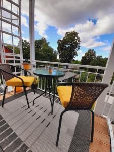 un patio con tavolo e sedie sul balcone. di Rosenwinkel Maisonettewohnung DG a Halberstadt