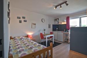 a bedroom with a bed and a kitchen with a table at Quai De Rome in Liège