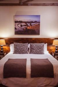 a bedroom with a large bed with two lamps at Bushveld Terrace - Hotel on Kruger in Phalaborwa