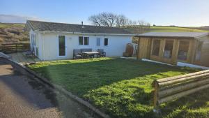 a house with a yard with a table and a bench at Penmor in Bude