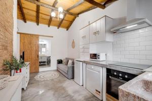 a kitchen with white appliances and a couch at Casa da Travessa - Lago do Alqueva in São Marcos do Campo
