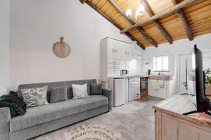 a living room with a couch and a kitchen at Casa da Travessa - Lago do Alqueva in São Marcos do Campo