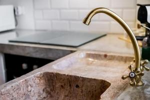 a sink in a kitchen with a faucet at Casa da Travessa - Lago do Alqueva in São Marcos do Campo
