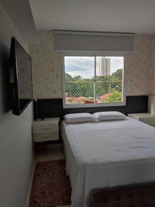 een kleine slaapkamer met een bed en een raam bij Apto com conforto que você precisa. in Goiânia