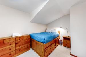 - une chambre avec un lit et une commode en bois dans l'établissement Mt Ellen Minikin, à Waitsfield