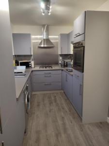 a kitchen with white cabinets and a stove top oven at Taigh Shen in Stornoway