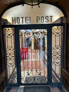 una entrada a un puesto de hotel con una puerta de hierro forjado en City Hotel Post 12 en Braunau am Inn