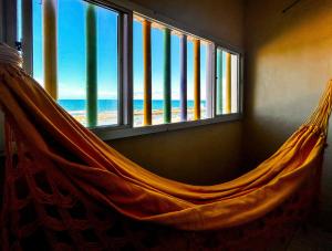 カマサリにあるKitnet beira mar com WiFi em Arembepe Camacari BAのビーチを望む客室内のハンモック