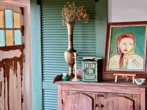 a vase sitting on top of a cabinet with a painting at The Vigneron's Cottage at Dragonfly Estate Vineyard - Stanthorpe in Severnlea