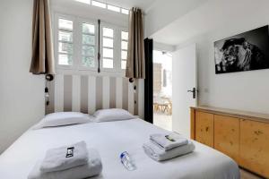 um quarto com uma cama branca e toalhas em Magnificent loft Porte Versailles & Champs de Mars em Paris