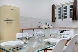 uma mesa de jantar com cadeiras brancas e um vaso de flores em Magnificent loft Porte Versailles & Champs de Mars em Paris