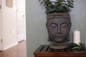 een standbeeld van een hoofd met een kaars op een tafel bij Bali Bliss Updated & Well-Appointed Condo in Gainesville