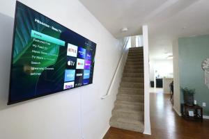 een flatscreen-tv hangend aan een muur in een hal bij Bali Bliss Updated & Well-Appointed Condo in Gainesville