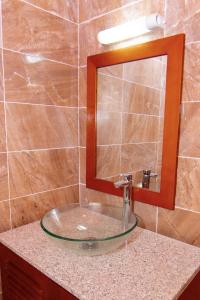 La salle de bains est pourvue d'un lavabo et d'un miroir sur un comptoir. dans l'établissement BUNGALOW'S PLAZA KRIBI, à Kribi