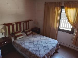 1 dormitorio con cama y ventana en Cabañas Campo Dulce Esperanza en Bialet Massé