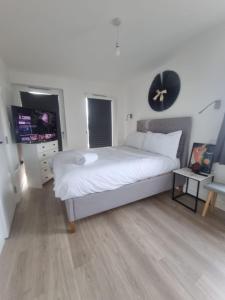 een slaapkamer met een bed met een klok aan de muur bij Beckenham- Stunning Double Bedroom With En-suite in SHARED APARTMENT in Elmers End