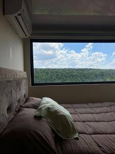 a bedroom with a bed and a large window at Container Home Py in Puerto Presidente Franco