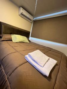 Bett mit Handtuch auf dem Zimmer in der Unterkunft Container Home Py in Puerto Presidente Franco