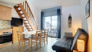 uma sala de estar com mesa e cadeiras e uma cozinha em Appartement 3 pièces 5 à 6 personnes - vue mer - à 200 m de la plage - FANTA em Ploemeur