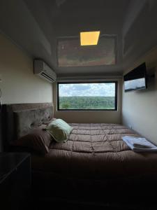 Puerto Presidente FrancoにあるContainer Home Pyの窓付きの小さな部屋のベッド1台分です。
