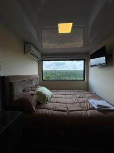 a bed in a small room with a window at Container Home Py in Puerto Presidente Franco