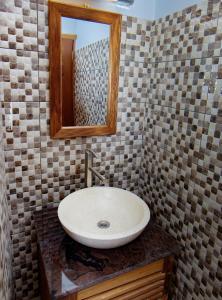 a bathroom with a sink and a mirror at BUNGALOW'S PLAZA KRIBI in Kribi