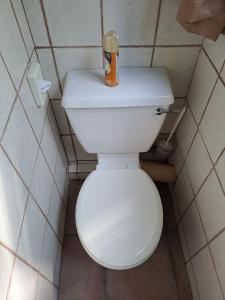 a bathroom with a toilet with a bottle on top of it at Belle Vue Guesthouse in Hartbeespoort