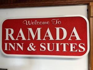 ein rotes Schild, das sagt, willkommen bei Rameda in und Suiten in der Unterkunft Ramada by Wyndham Saginaw Hotel & Suites in Saginaw