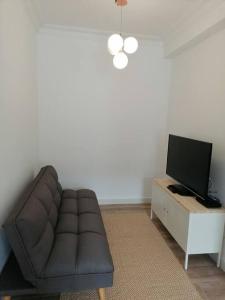 ein Wohnzimmer mit einem Sofa und einem TV in der Unterkunft Apartamento completamente equipado centro Ferrol in Ferrol