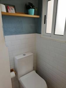 łazienka z białą toaletą i oknem w obiekcie Apartamento completamente equipado centro Ferrol w mieście Ferrol