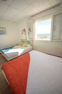 1 dormitorio con 2 camas y ventana en Hotel Camille, en Saintes-Maries-de-la-Mer