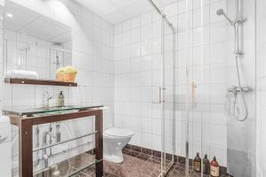 a white bathroom with a shower and a toilet at Ocean-view Haven: Take a swim from your window! in Bergen