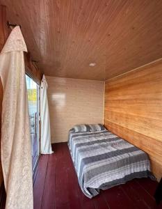 Bett in einem Holzzimmer mit Fenster in der Unterkunft Flutuante Long Beach Manaus Am in Manaus