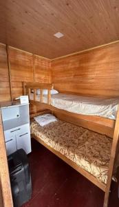 a small room with two bunk beds and a refrigerator at Flutuante Long Beach Manaus Am in Manaus