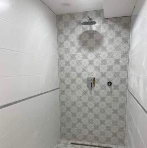 y baño con ducha y pared de azulejos. en Hajnal Vendégház, en Kéked