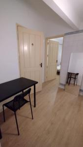 Zimmer mit einem Tisch, einer Bank und einer Tür in der Unterkunft Varandas do chiado - Lisboa in Lissabon
