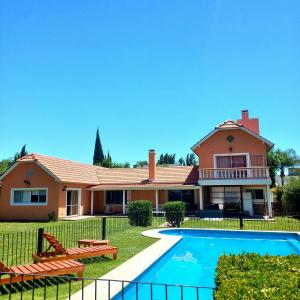 una casa con piscina frente a ella en CASA BARRIO CERRADO EN LUJAN LA CONCEPCION en Luján