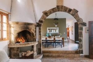a living room with a fireplace and a dining room at Villa Margarita - Ampia villa situated in Lardos in Lardos