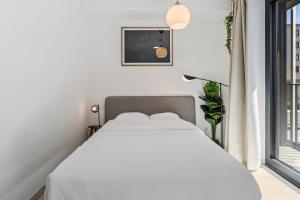 a white bedroom with a bed and a window at Classy Studio next to Belval Shopping Plaza-ID-176 in Esch-sur-Alzette