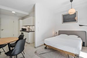 1 dormitorio con 1 cama, mesa y sillas en Classy Studio next to Belval Shopping Plaza-ID-176 en Esch-sur-Alzette